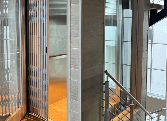 Elevator in a modern home near a staircase