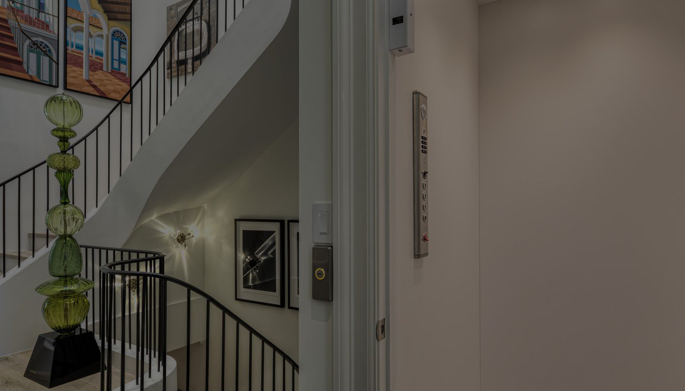 Open elevator next to a winding staircase