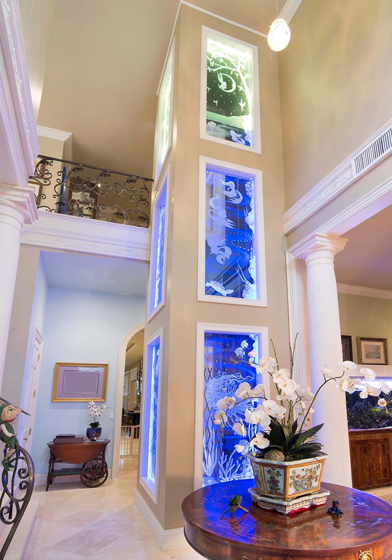 Illuminated home elevator shaft with ocean-themed glass panels