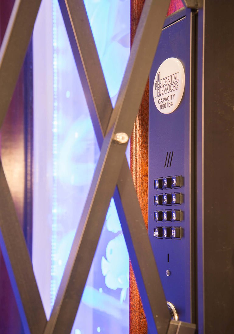 Close-up of a home elevator keypad behind a metal gate