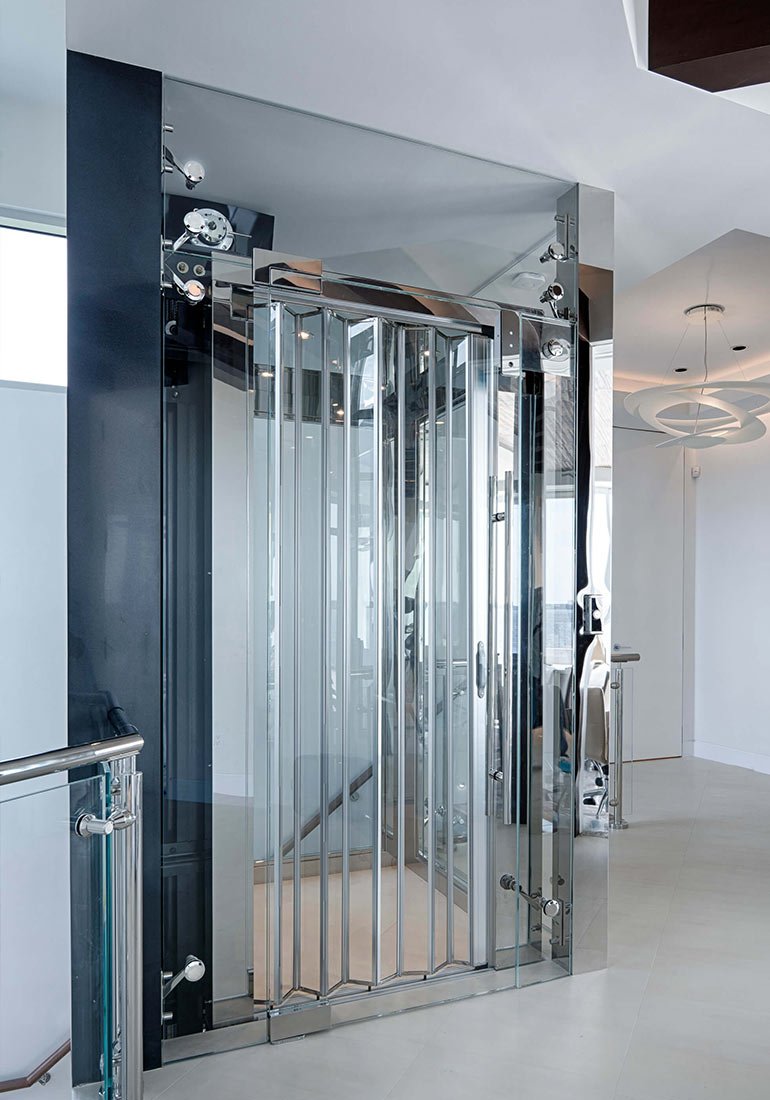 Glass home elevator with metal accordion doors