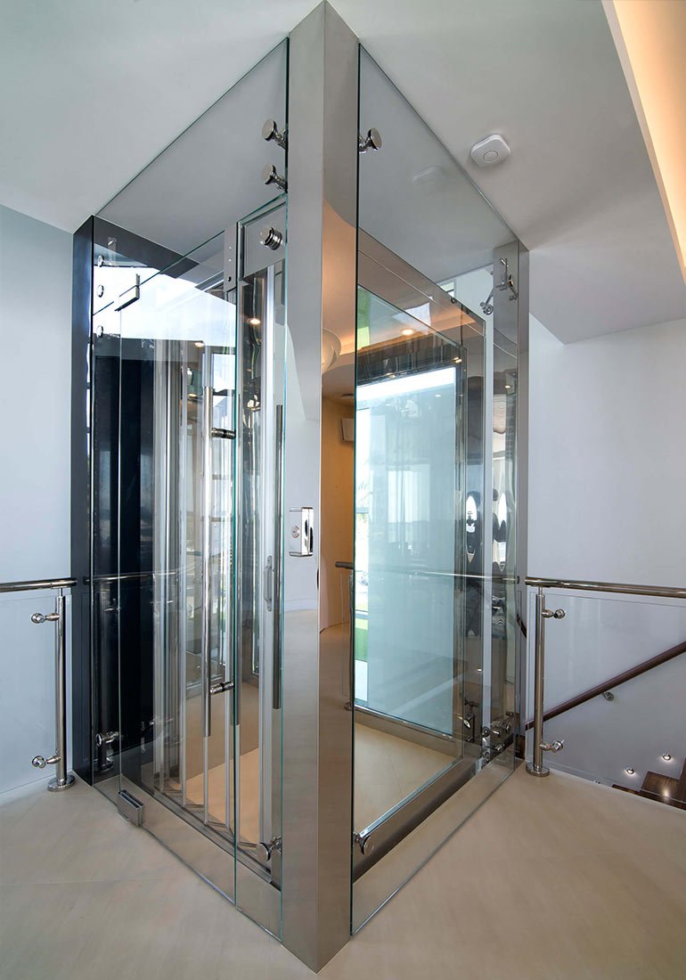 Glass home elevator with metal accordion doors