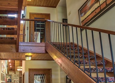 Wood-accented interior with multi-level stairs and an elevator with a metal accordion gate