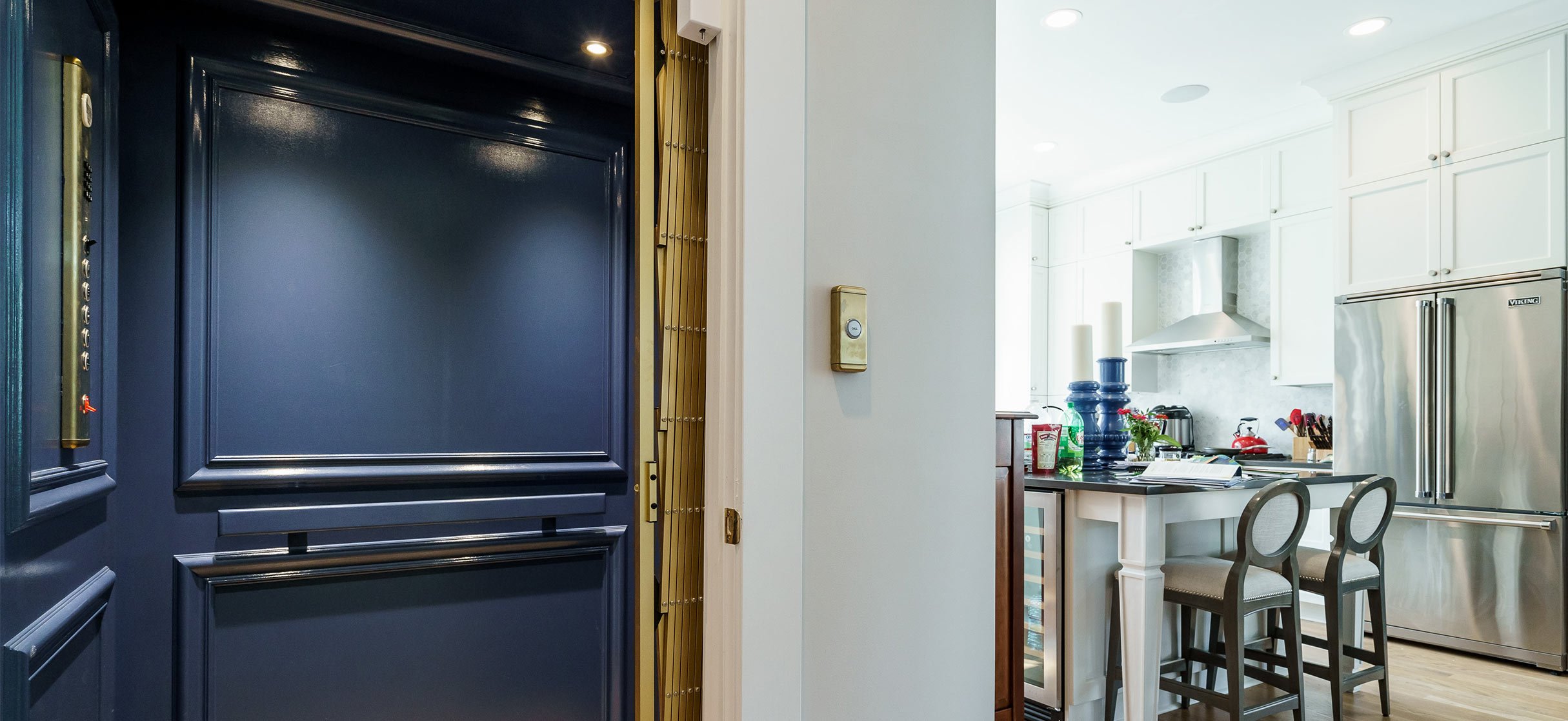 Home elevator with dark blue interior opening into a bright white kitchen