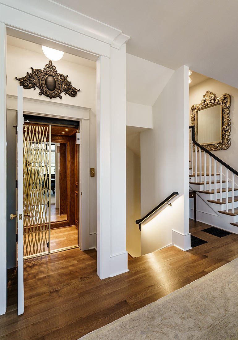 Home elevator with a gold gate beside a staircase