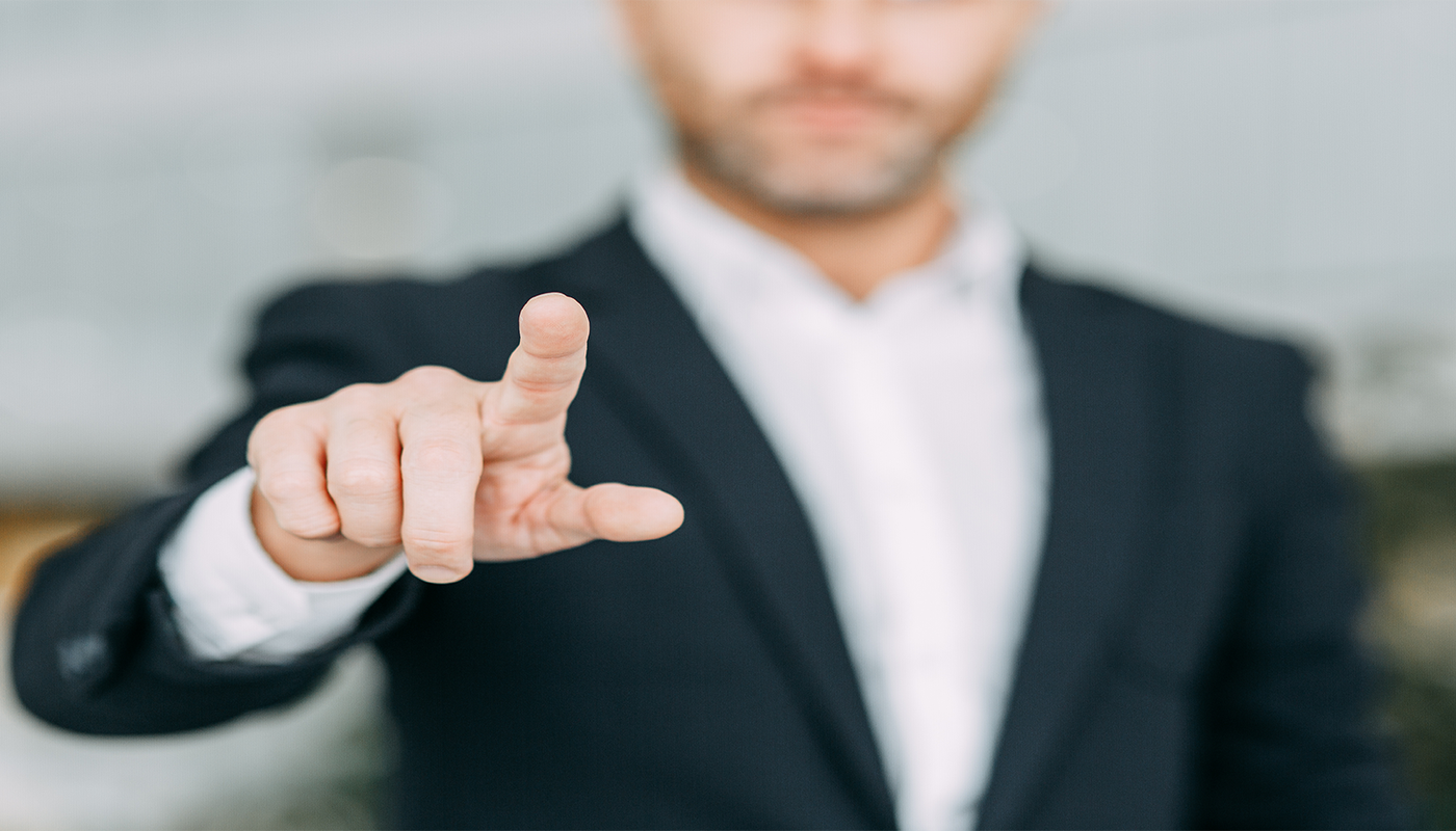 Man in a suit pointing at a touchscreen
